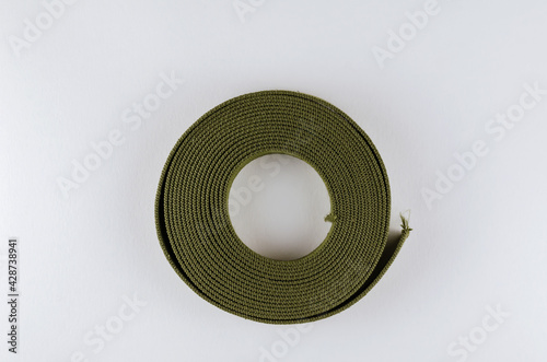 A roll of green cotton ribbon on a white background. photo