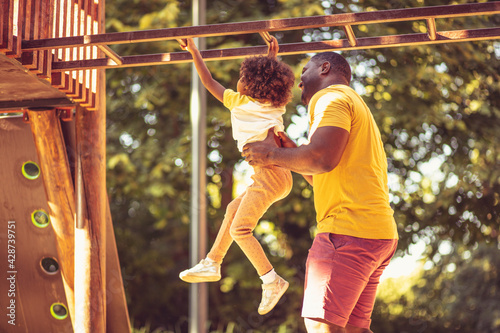 Active and funny time. Father and daughter on playground.