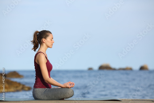 Profile of a woman doing yoga on the beach