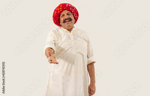 A TURBANED RURAL MAN HAPPILY SINGING IN FRONT OF CAMERA	 photo