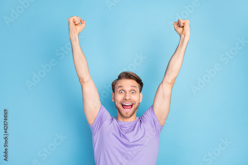 Photo portrait of guy overjoyed amazed gesturing like winner isolated on pastel blue color background