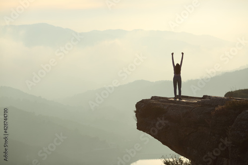 Woman celebrating raising arms in the mountain