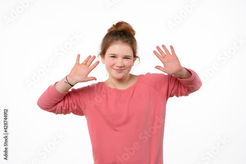 Studio portrait of cheerful young girl making funny face. White background