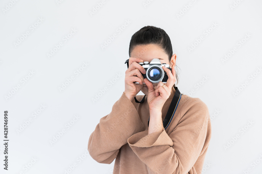 Front view of stylish pretty girl taking a picture with vintage camera.Isolated on white background.Copy space Front view of stylish pretty girl taking a picture with vintage camera.Isolated on white background.Copy space