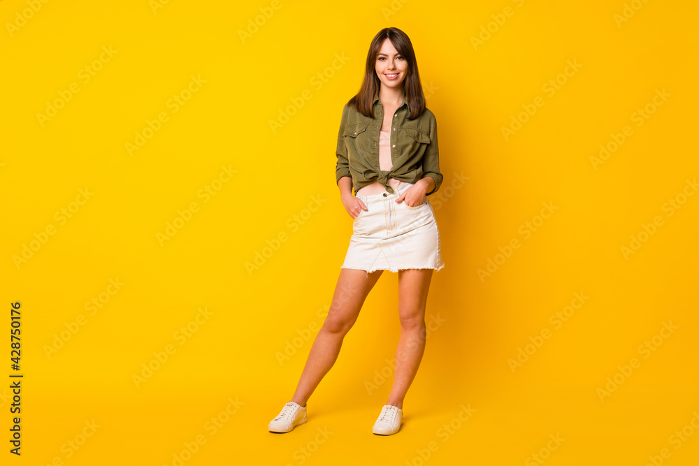 Photo of charming young lady wear green shirt mini skirt footwear isolated vivid yellow color background - obrazy, fototapety, plakaty 