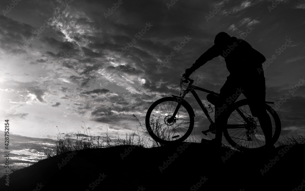 Obraz premium cyclist with a bicycle, on the black background .