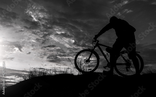 cyclist with a bicycle, on the black background .