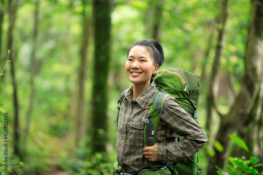 Woman backpacker hiking in spring forest