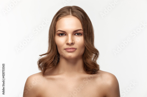Beautiful tanned brunette girl on a gray background