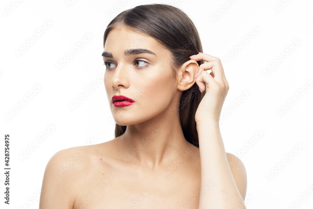 nude woman with red lips touching hair on her head on a white background