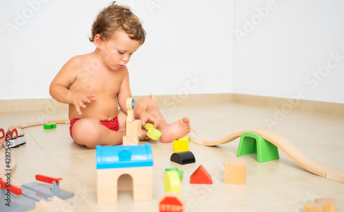 Child making structures with wooden toys.