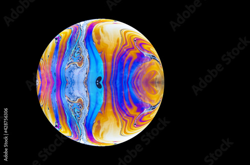 close up of a soap bubble. Close up of a abstract, soap bubble resembling a planet. Copy space on a black background. photo