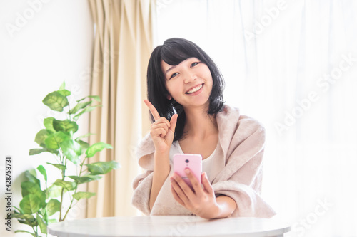 スマホを持つ若い女性のイメージ