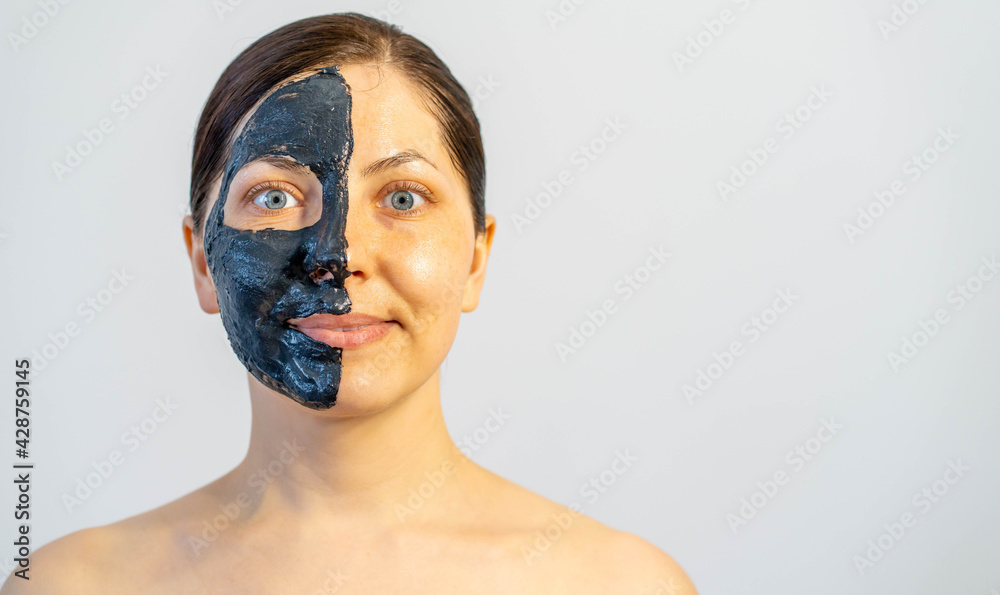 Woman relaxing with black charcoal facial mask Woman relaxing with black charcoal facial mask
