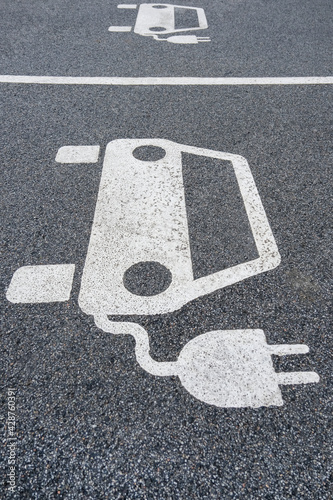 Parkplatz für Elektrofahrzeuge, E-Autos, Elektroautos mit weißem Symbol zum Aufladen, E-Tankstelle, Copy Space, Hochformat