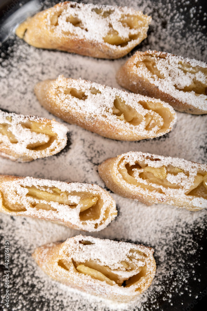 Apple roll with powdered sugar. Close up. Vertical frame