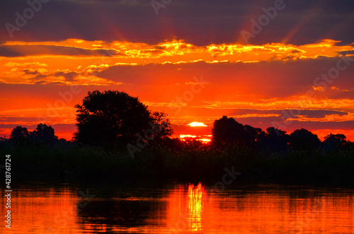 Sunrise over lake and trees with reflection