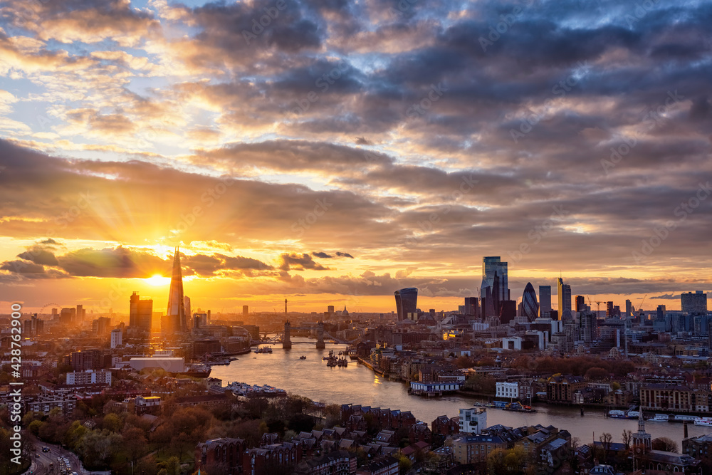 The urban skyline of London, United Kingdom, with Tower Bridge, Thames river and City district during a colorful sunset