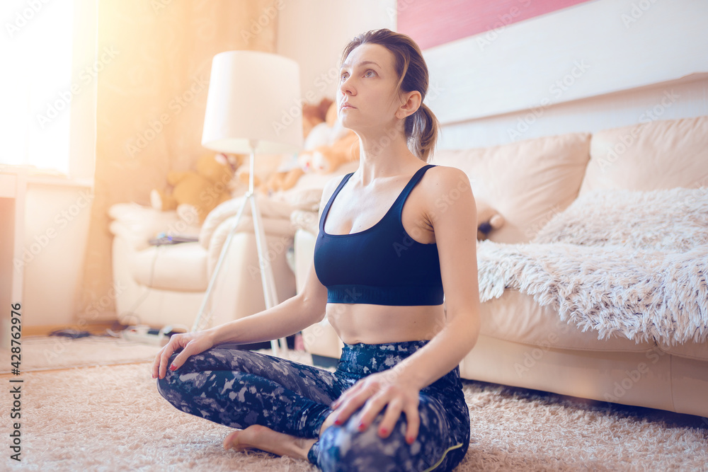 Woman is practicing yoga, gymnastic exercises for neck while sit Woman is practicing yoga, gymnastic exercises for neck while sit