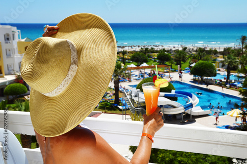 Fototapeta Naklejka Na Ścianę i Meble -  Woman with drink on the balcony in a tourist resort