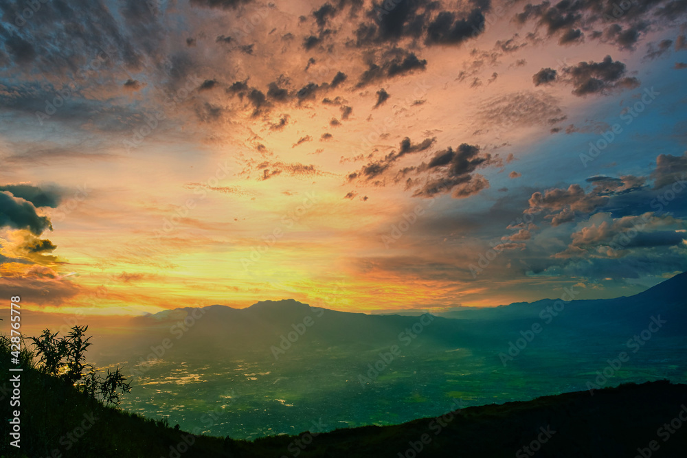 Obraz premium Beautiful sunset view from the top of the mountain Indonesia. Beautiful landscapes with high mountains with illuminated peaks
