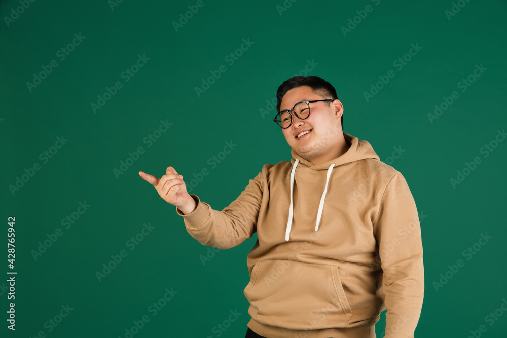 Asian man's portrait isolated over green studio background with copyspace Asian man's portrait isolated over green studio background with copyspace