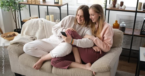 Lesbian couple using mobile phone at home