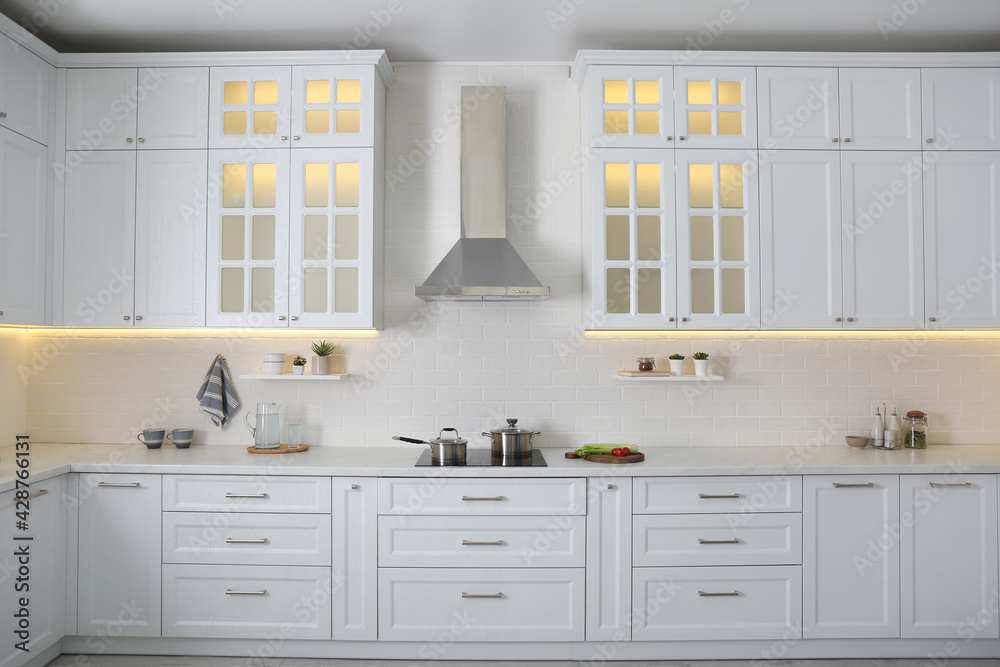 Fototapeta premium Elegant kitchen interior with modern stove and stylish furniture