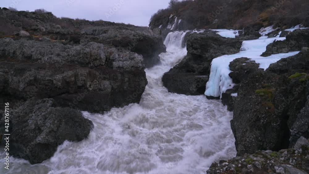 Turbulent Foamy Water In Wild River Flowing Through The Mountain Rocks. Barnafoss Waterfall In Iceland. tilt down, panning left Turbulent Foamy Water In Wild River Flowing Through The Mountain Rocks. Barnafoss Waterfall In Iceland. tilt down, panning left