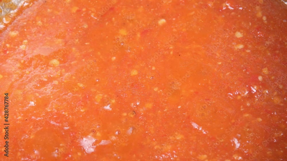 hot chili sauce is cooked on the stove. ketchup or tomato sauce or soup while cooking hot chili sauce is cooked on the stove. ketchup or tomato sauce or soup while cooking