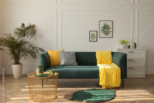 Stylish living room interior with comfortable green sofa photo