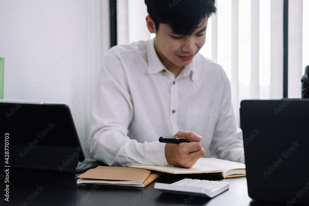 Businessman holding pen and taking note when meeting at office Businessman holding pen and taking note when meeting at office
