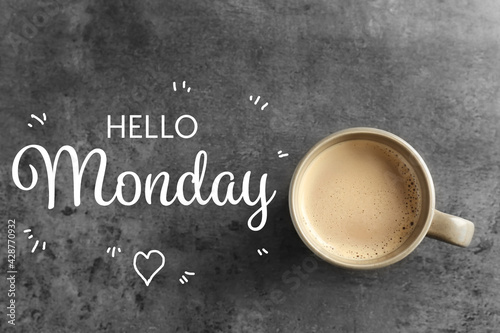 Cup of hot aromatic coffee and phrase Hello Monday on grey background, top view