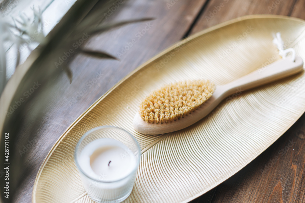 Details of interior, aromatic candle in glass and wooden brush with natural bristles on metal tray on wooden window sill Details of interior, aromatic candle in glass and wooden brush with natural bristles on metal tray on wooden window sill