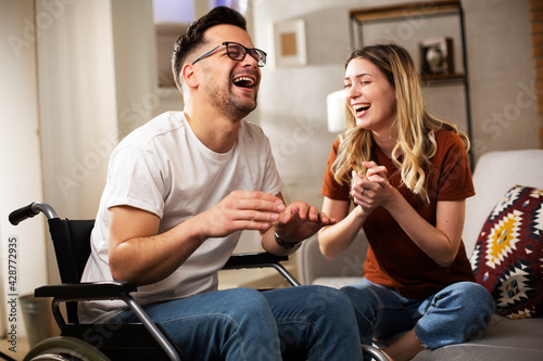 Young man in wheelchair. Wife and hausband talking and laughing.. photo