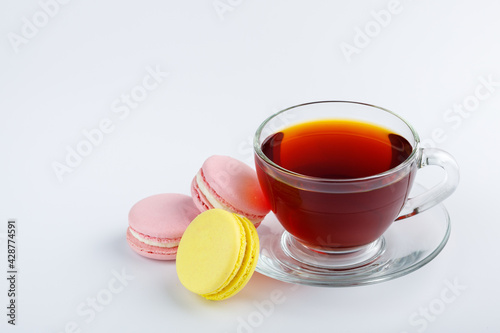 Cup of tea and colorful macaroons on a white background.
