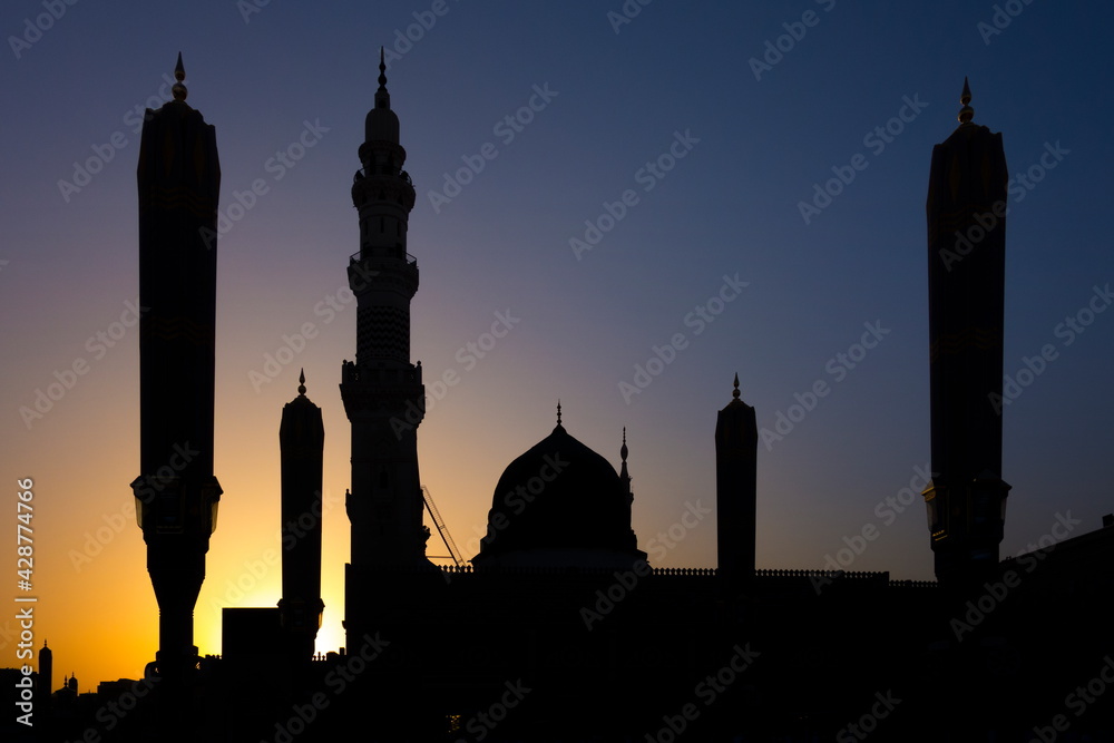 THE HOLY MASJID AL- NABAWI ALONG WITHE THE BEAUTIFUL YELLOW SKY AND THE GREEN DOME AND THE WHITE MINARETS 