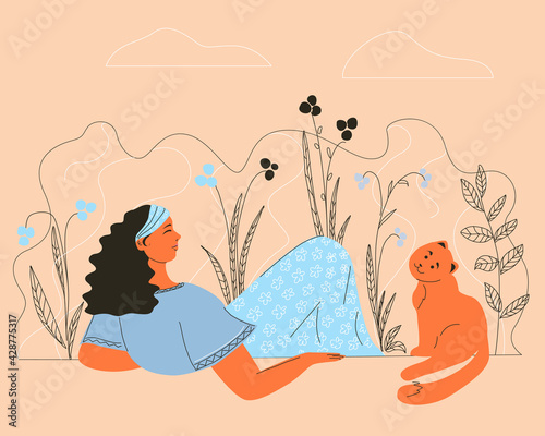 Girl with a cat resting on the grass