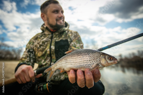 Fishing. Fisherman and white fish roach. Blurred background.