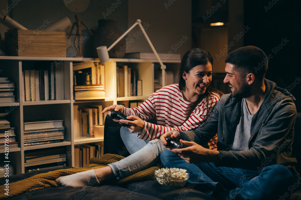 couple spending evening together at home. they are playing video games