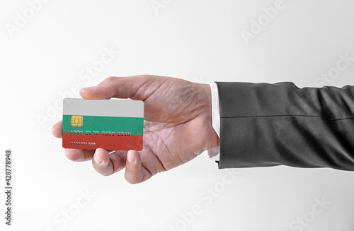 Bank credit plastic card with flag of Bulgaria holding man in elegant suit