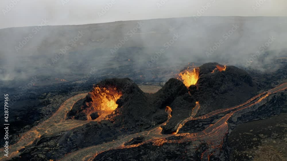 Aerial view of lava craters, surrounded by by smoke - still, drone shot