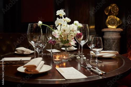 beautifully served table with white flowers in the center and transparent wine glasses