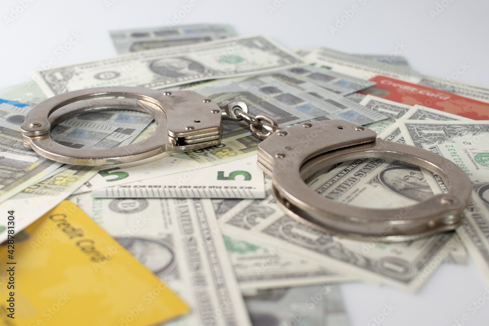 Dollar ,euro , credit cards and police handcuffs on a white background Dollar ,euro , credit cards and police handcuffs on a white background