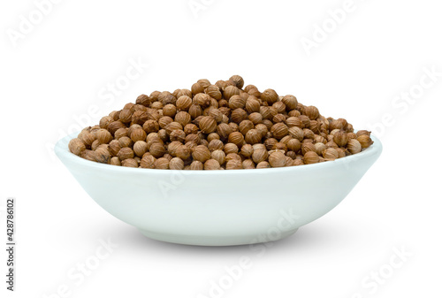 dried coriander seeds in ceramic bowl isolated on white background ,include clipping path