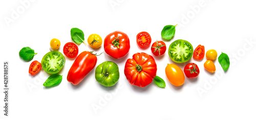 Fresh ripe tomatoes of different varieties with basil leaves isolated on white panoramic background