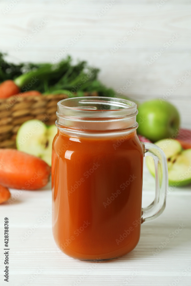 Jar of apple - carrot juice and ingredients on white wooden background Jar of apple - carrot juice and ingredients on white wooden background