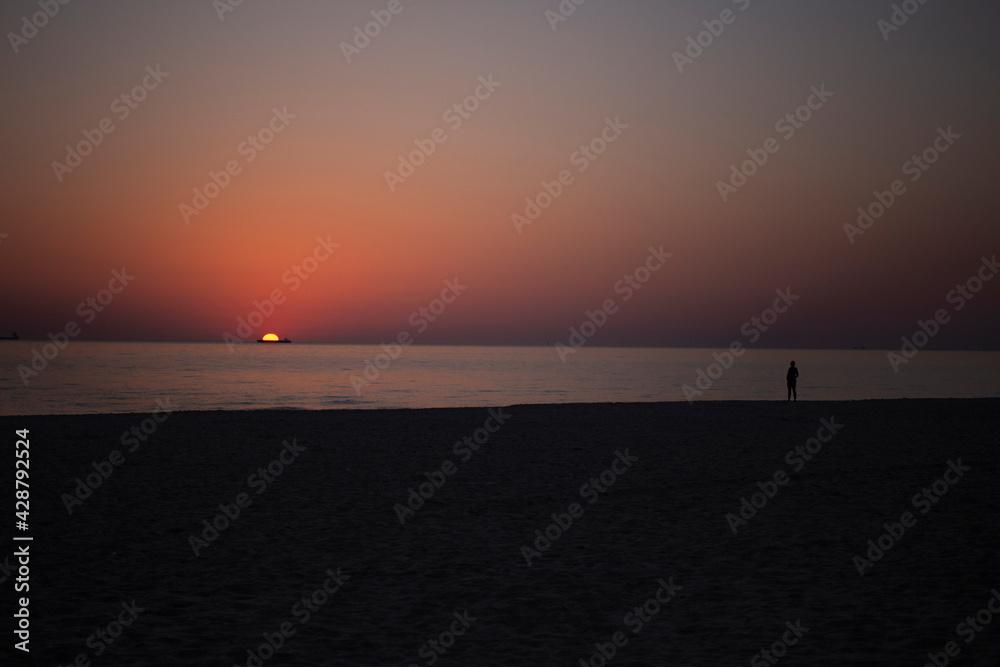 Fototapeta premium orange sunrise at sea with the silhouette of the container ship