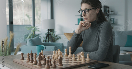 Woman playing chess at home