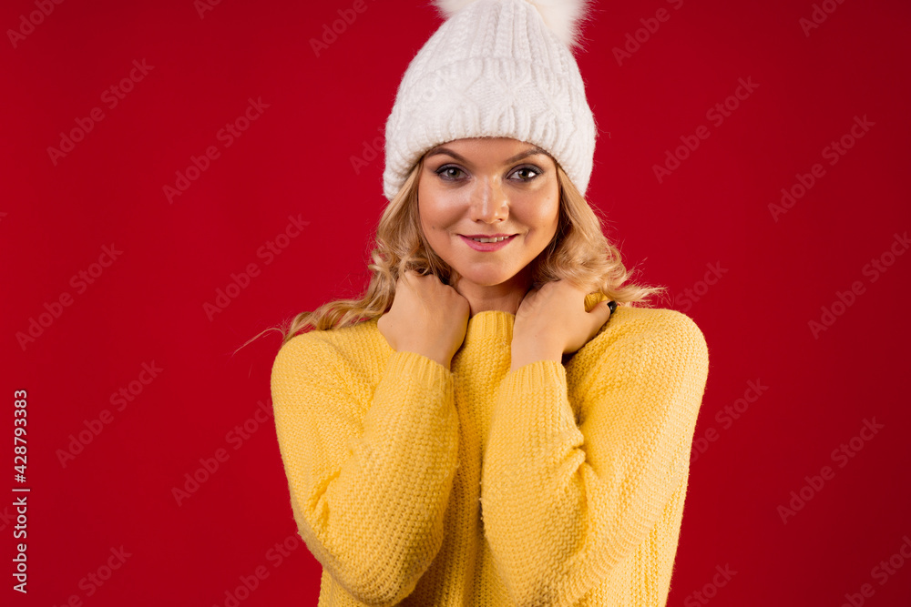 young sweet and smiling blonde woman in a yellow knitted sweater on a red background, young sweet and smiling blonde woman in a yellow knitted sweater on a red background,